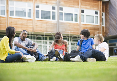 College students sitting and talking on campus lawn