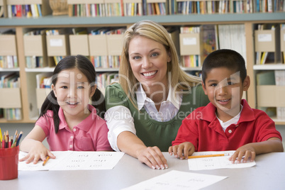 Kindergarten teacher helping students learn writing skills