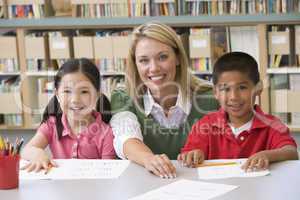 Kindergarten teacher helping students learn writing skills