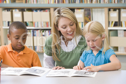 Kindergarten teacher helping students with reading skills