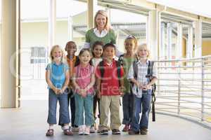 Kindergarten teacher standing with children in corridor