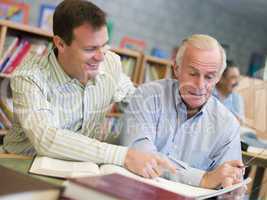 Tutor assisting mature student in library