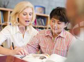 Tutor assisting mature student in library