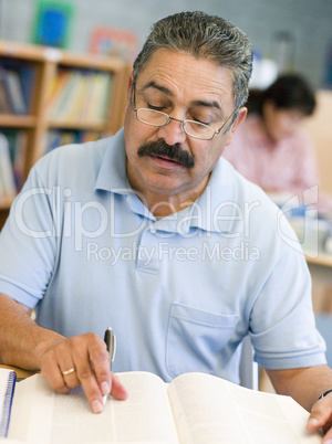 Mature male student studying in library