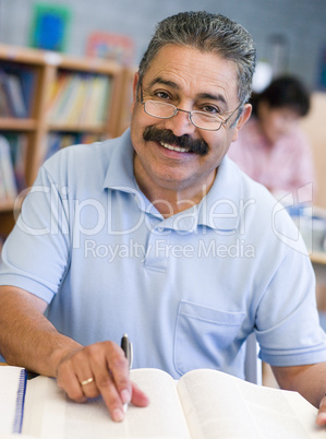 Mature male student studying in library