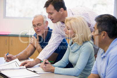 Teacher assisting mature students in class