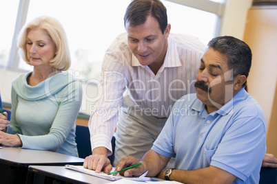 Teacher assisting mature student in class