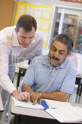 Teacher assisting mature student in class