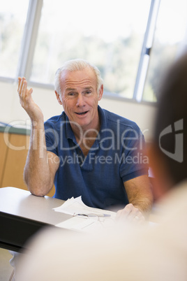 Mature male student gesturing in class