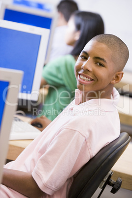 Schoolboy sitting in front of a computer in a high school class