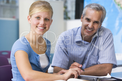 A teacher instructs a schoolgirl in a high school class