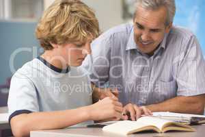 A teacher instructs a schoolboy in a high school class