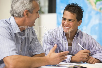 A teacher instructs a schoolboy in a high school class