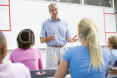 A teacher talks to school children in a high school class