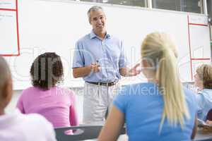 A teacher talks to school children in a high school class