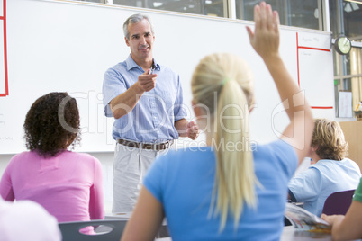 A teacher talks to school children in a high school class