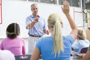 A teacher talks to school children in a high school class