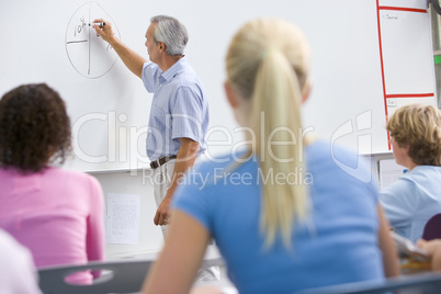 A teacher talks to school children in a high school class