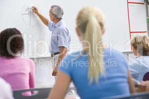 A teacher talks to school children in a high school class