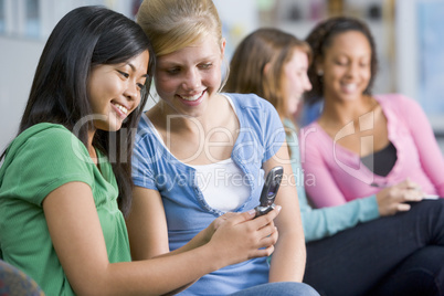 Teenage girls looking at a mobile phone
