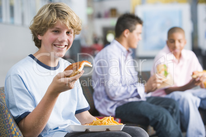 Teenage boys enjoying fast food lunches together