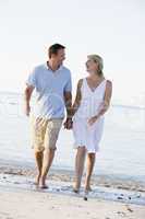 Couple at the beach holding hands and smiling