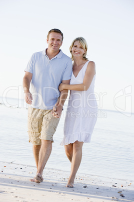 Couple at the beach holding hands and smiling