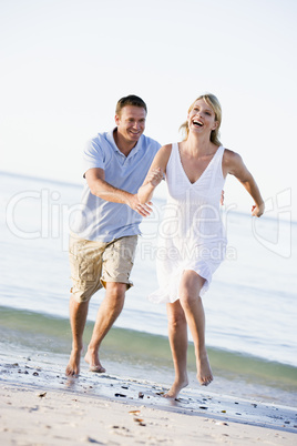 Couple at the beach playing and smiling