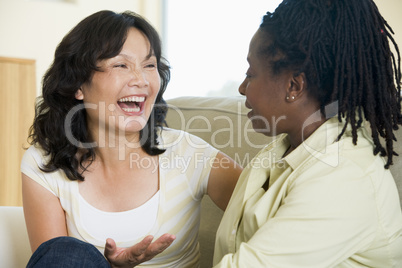 Two women talking in living room and smiling