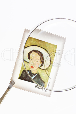 Postage stamp under magnifier with tweezers