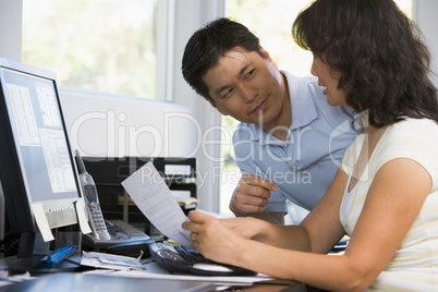Couple in home office with computer and paperwork