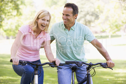 Couple on bikes outdoors smiling