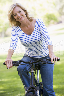 Woman on bike outdoors smiling