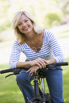 Woman on bike outdoors smiling