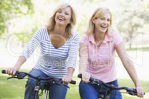 Two friends on bikes outdoors smiling