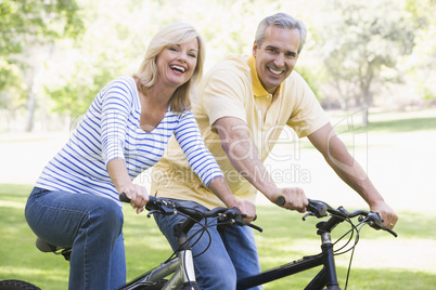 Couple on bikes outdoors smiling