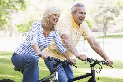 Couple on bikes outdoors smiling