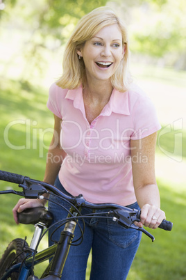 Woman with a bike outdoors smiling