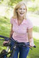 Woman with a bike outdoors smiling