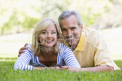 Couple relaxing outdoors in park smiling