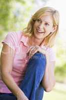 Woman sitting outdoors smiling