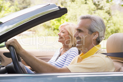 Couple in convertible car smiling