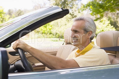 Man in convertible car smiling