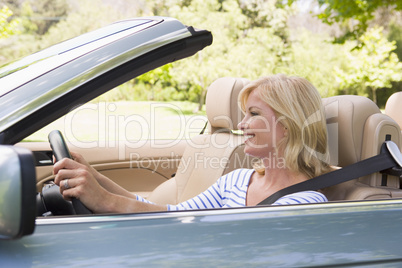 Woman in convertible car smiling