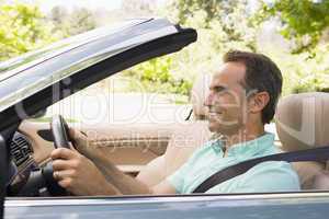 Man in convertible car smiling