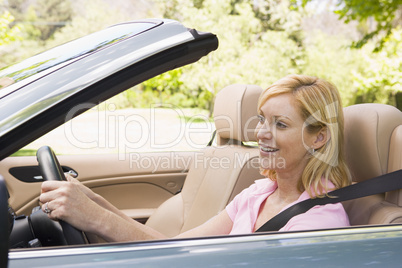 Woman in convertible car smiling