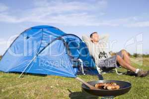Man camping outdoors and cooking