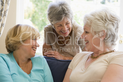 Three women in living room talking and smiling