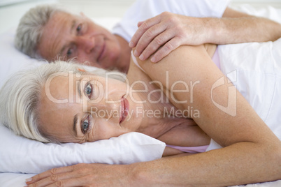Couple lying in bed together smiling