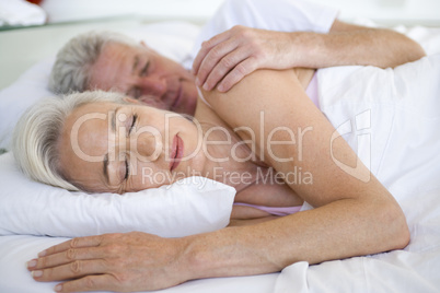 Couple lying in bed together sleeping